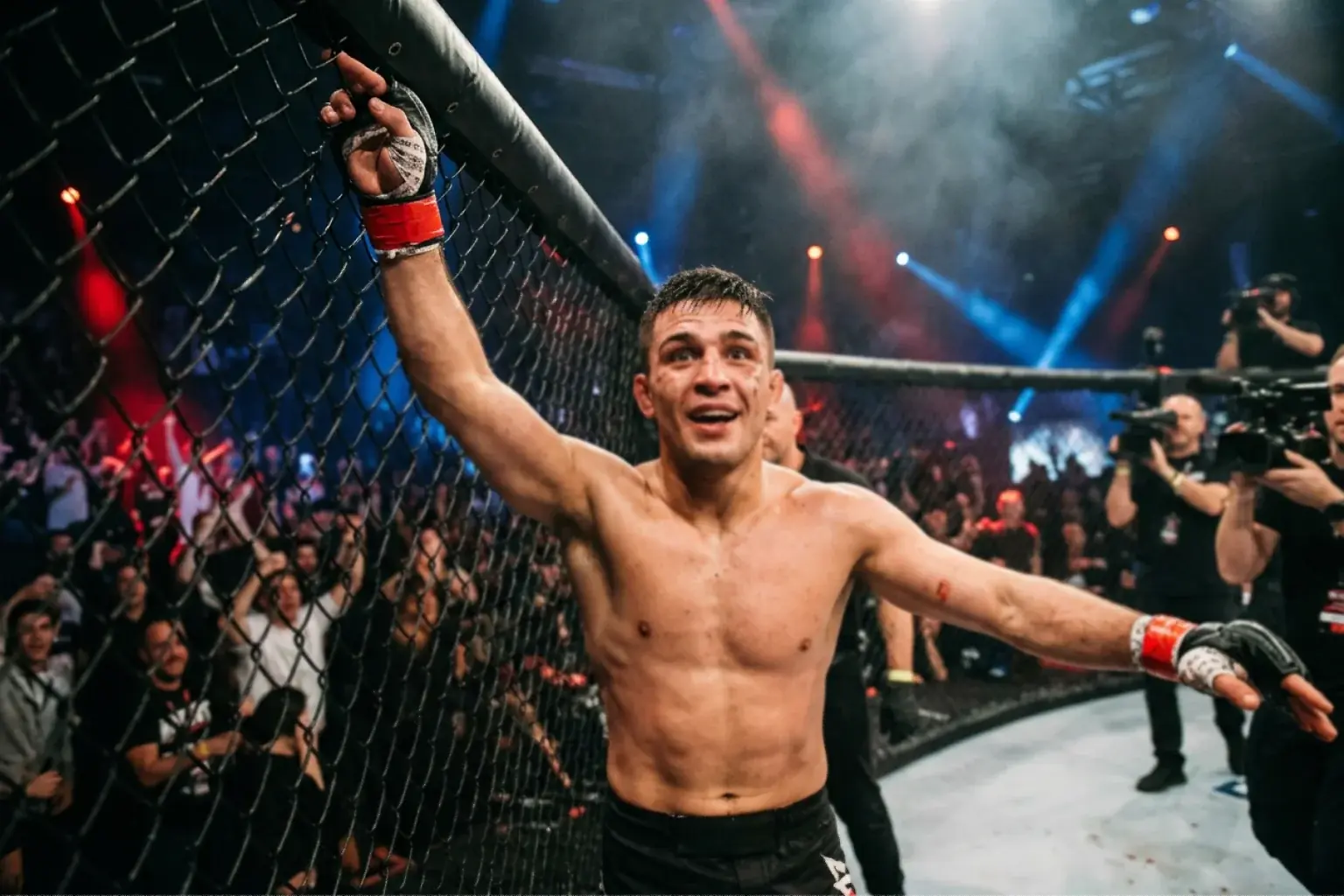 UFC-ottelija nostaa kätensä voiton merkiksi oktagonissa altavastaajan voiton jälkeen